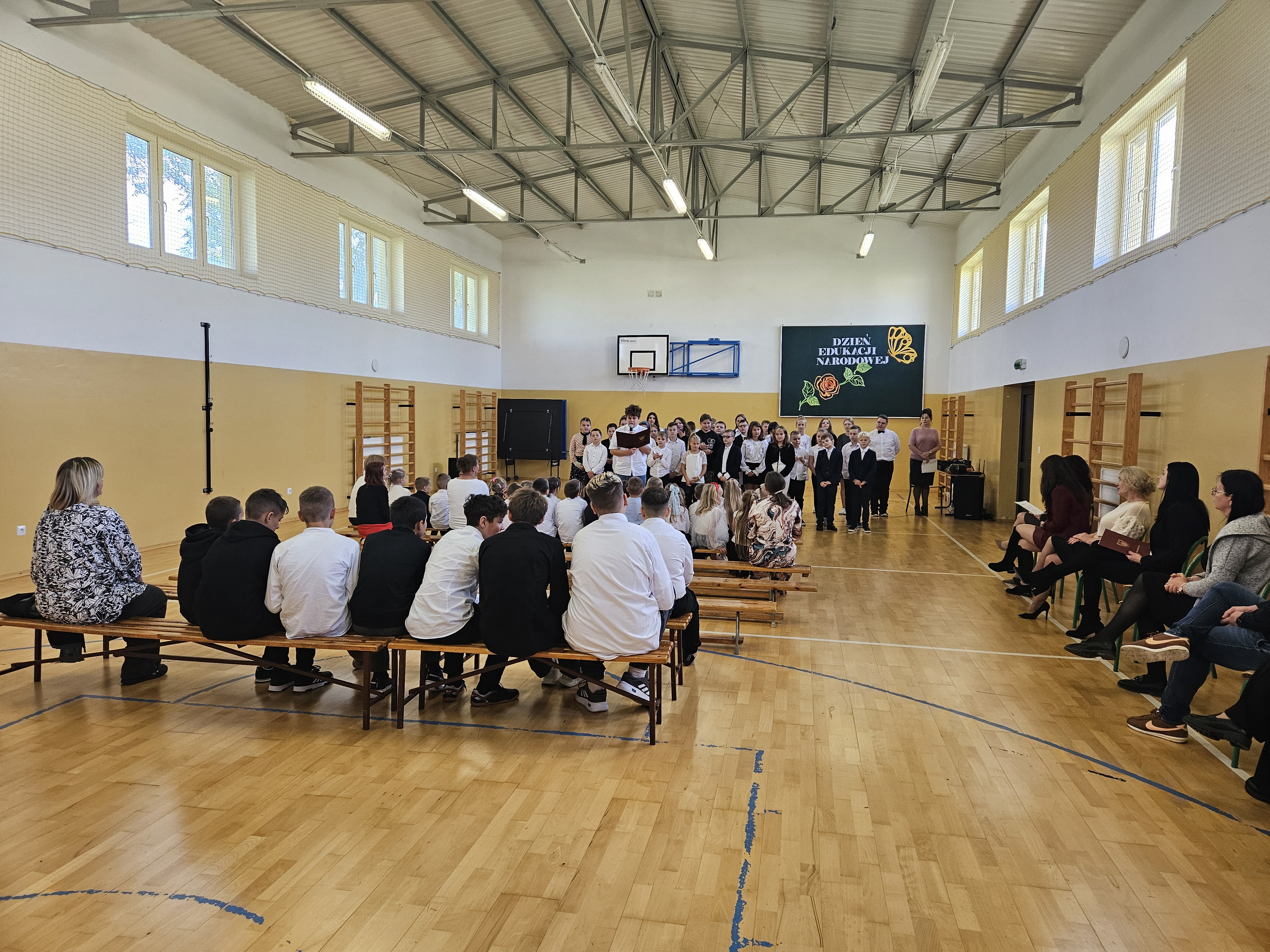 Grupa uczniów recytuje i śpiewa w trakcie występu.